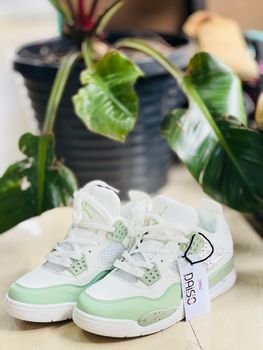 Fashionable green and white sneakers styled with indoor plant for fresh look.